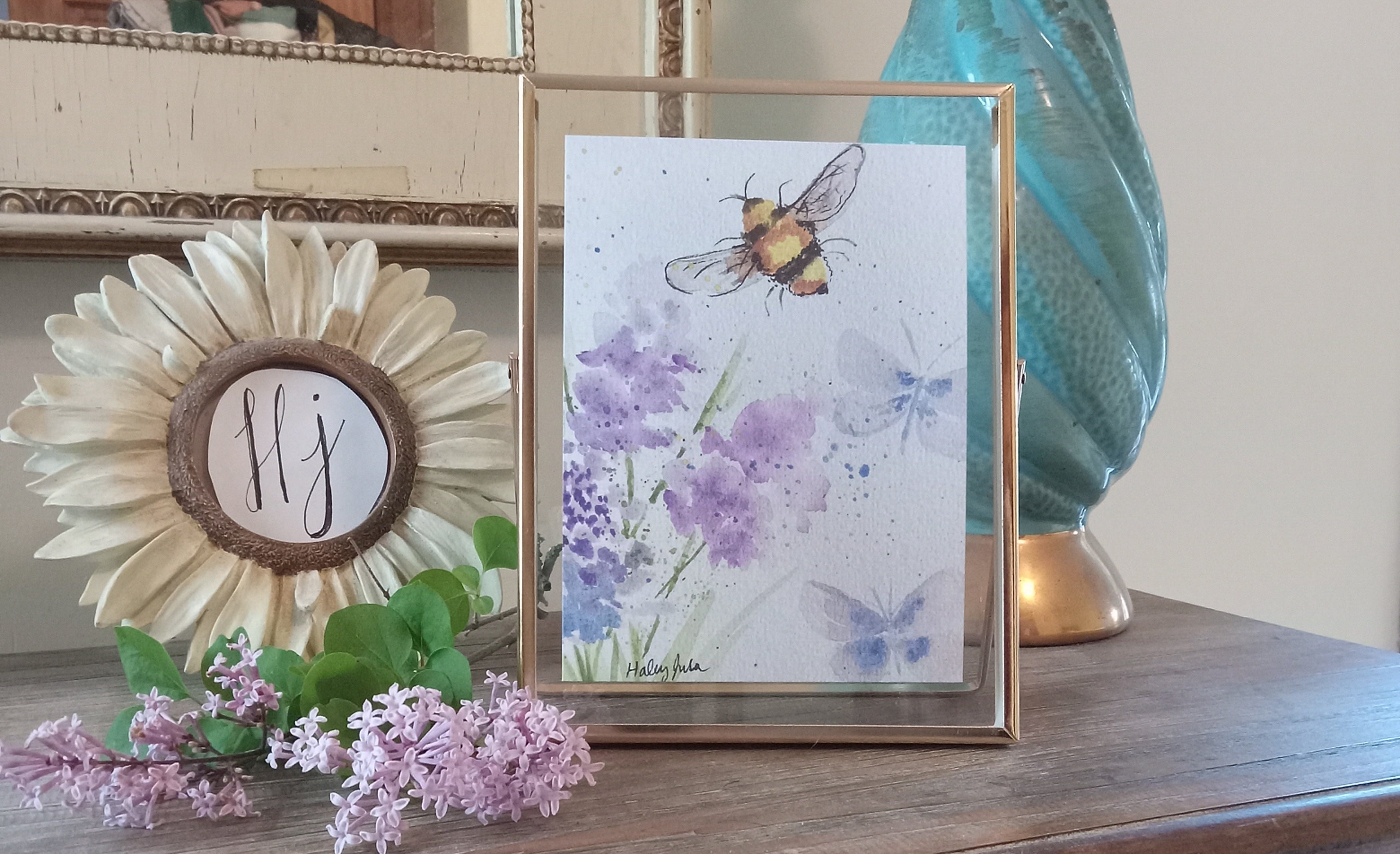 Decorative wall art with flowers and a bee on a wooden surface.